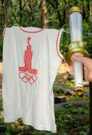 Olympic torch near a shirt with symbolism of Olympiad
