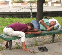 Man and woman sleeping on a bench