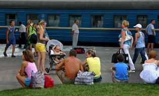 People sit on a border near the station