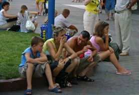 People sit on a border near the station