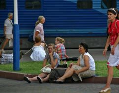 People sit on a border near the station
