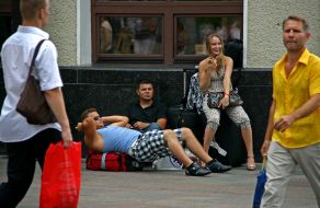 Passengers sit on the suitcases
