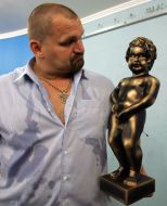 Василий Вирастюк держит копию символа Брюсселя ”Manneken Pis”