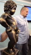 Василий Вирастюк держит копию символа Брюсселя ”Manneken Pis”