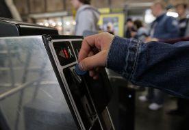 Passengers pass through a turnstile