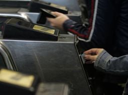 Passengers pass through a turnstile