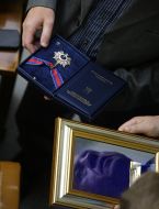 Народный депутат держит в руках награду