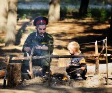 Казак и ребёнок сидят возле костра
