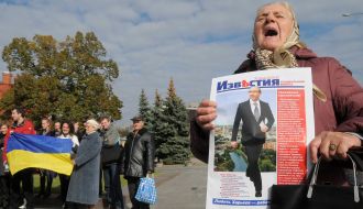 Пожилая женщина держит газету
