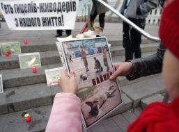 Девочка держит фотографию, на которой изображена мертвая собака