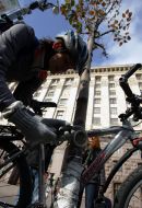 A girl ties a bicycle to the tree