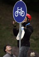Bicyclists hang a sign-board