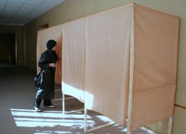 A woman checks the voting booth