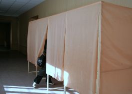 A woman checks the voting booth