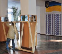 A worker brings wooden frameworks of polling-booths