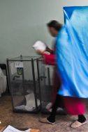 A pregnant woman goes out from the polling-booth