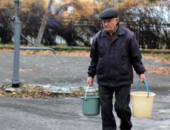 Мужчина несёт ведра с водой