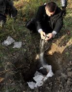 Співробітник УСБУ засипає в яму наркотики