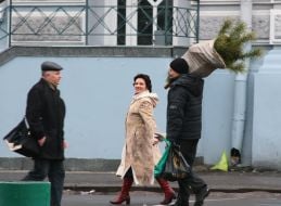 Мужчина несет елку