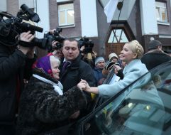 Yuliya Timoshenko presses a hand to the elderly woman
