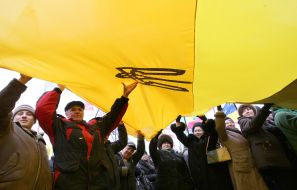 The participants of mass meeting hold the flag of Ukraine