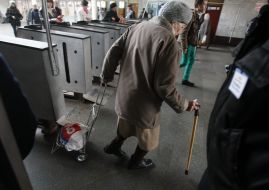 Літня жінка заходить в метро