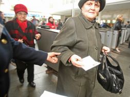 Літня жінка показує пенсійне посвідчення,