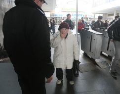 Літня жінка заходить в метро