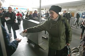 Літня жінка показує пенсійне посвідчення,