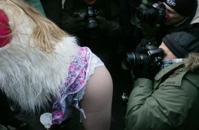 Photographers near an activist of FEMEN womanish motion