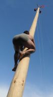 A man climbs a pole for the prize