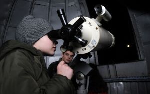 The young man looks through a telescope on the Moon