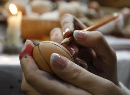 A girl paints Easter egg