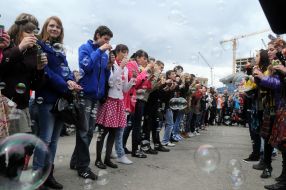 Young people inflate soap-bubbles