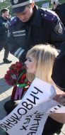 Милиционер задерживает активистку FEMEN