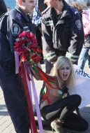 Милиционер задерживает активистку FEMEN