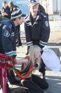 Милиционер задерживает активистку FEMEN