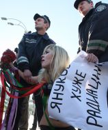 Милиционер задерживает активистку FEMEN