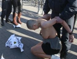 Милиционер задерживает активистку FEMEN