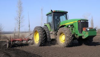 A tractor cultivates soil