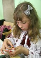 Кристина Микуляк украшает бисером пасхальное яйцо