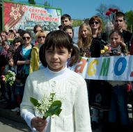 A girl holds lily of the valley