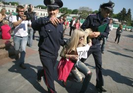 Співробітники міліції затримують активістку FEMEN