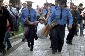 Співробітники міліції затримують активістку FEMEN