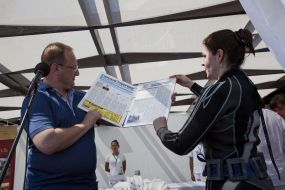 Journalists divers exhibit a newspaper, laid out under water
