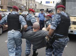 Militiamen carry a detainee