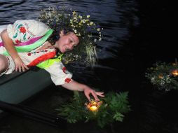 The girl puts the candle on the water