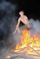 The young man jumps over a fire