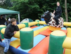 Young people ride Rodeo Bull attraction