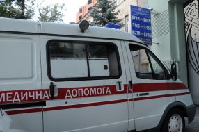 Автомобиль скорой помощи возле вывески с курсом валют